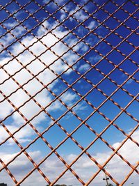 Close-up of chainlinked fence against sky