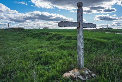 Wooden posts on field against sky