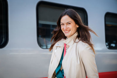 Portrait of young woman standing in car