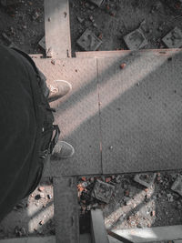 Low section of person standing on sidewalk in city