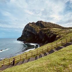 Scenic view of sea and mountains against sky in jeju island