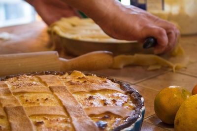 Cropped image of person preparing pie in kitchen