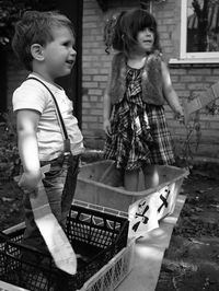 Cute siblings holding swards while standing in baskets