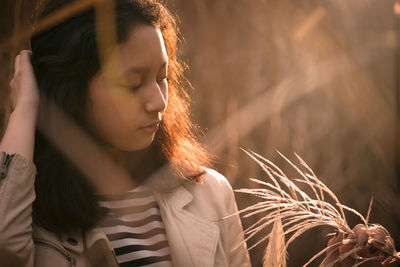 Close-up of young woman holding plant