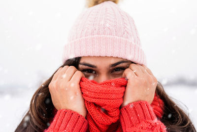 Portrait of woman wearing knit hat standing outdoors during winter