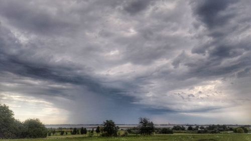 Scenic view of field against cloudy sky