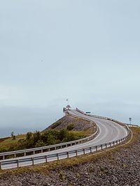 Road leading towards bridge against sky