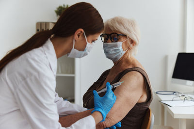 Doctor vaccinating senior patient at clinic