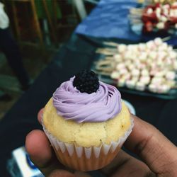 Cropped hand of person holding cupcake