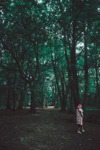 Full length of woman standing on tree trunk