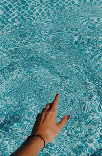 Close-up of woman touching water in swimming pool