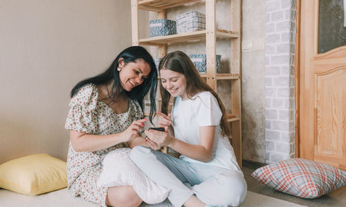 Portrait of young woman sitting on sofa at home