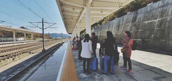 Rear view of people on railroad station platform