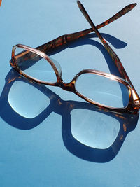 Close-up of sunglasses against blue sky