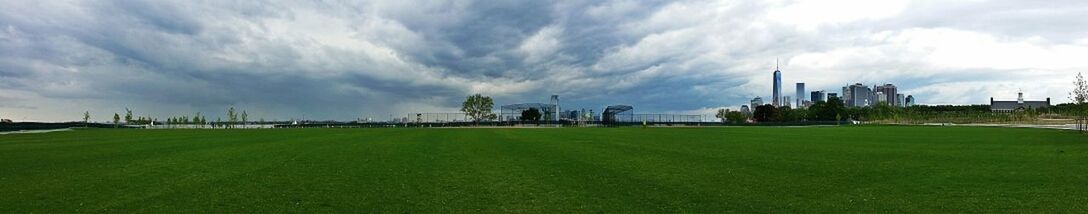 Scenic view of grassy field against cloudy sky