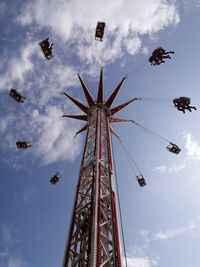 Low angle view of chain swing ride against sky