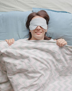 High angle view of woman lying on bed at home