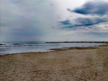 Scenic view of beach against sky at dusk