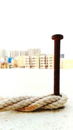 Rope tied on bollard against clear sky