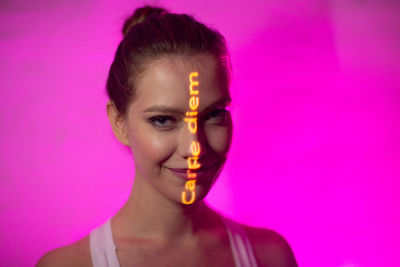 Portrait of woman against pink background