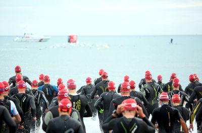 Group of people in sea against sky