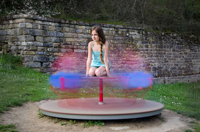 Girl playing on merry-go-round at playground