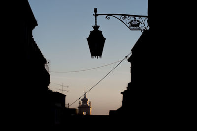 Low angle view of silhouette lanterns hanging against sky