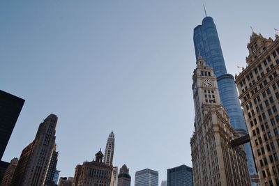 Low angle view of skyscrapers against blue sky