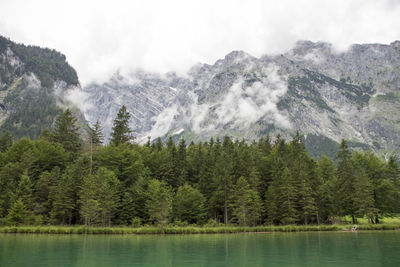 Scenic view of mountains and lake against cloudy sky