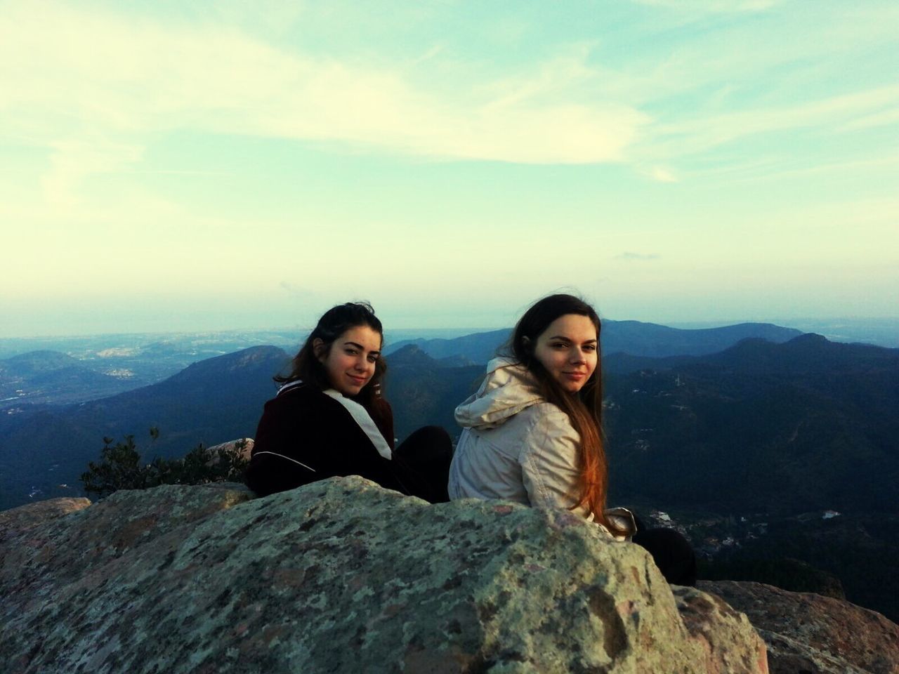 lifestyles, leisure activity, mountain, person, togetherness, young men, casual clothing, young adult, smiling, looking at camera, portrait, bonding, sky, vacations, happiness, mountain range, sitting