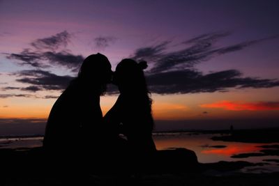 Silhouette couple against sea during sunset