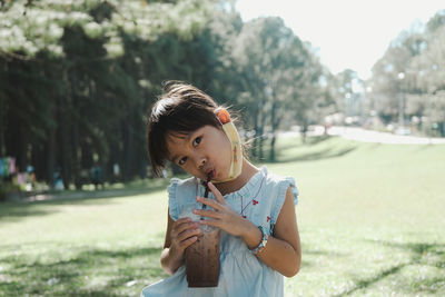 Portrait of cute girl drinking smoothie outdoors