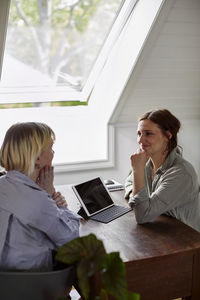 Women sitting at desk and talking