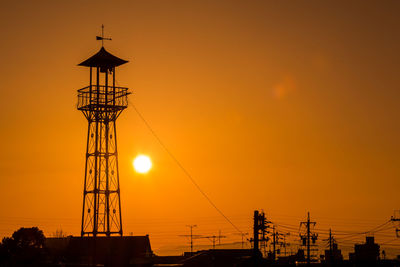 Silhouette cranes against sky during sunset