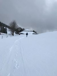 Man skiing on snow against sky