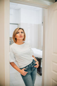 Portrait of a beautiful slender woman in the doorway of a bright medical office. the proprietress of