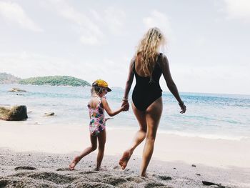 Full length of woman on beach against sky