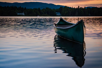 Boat moored in lake against sky