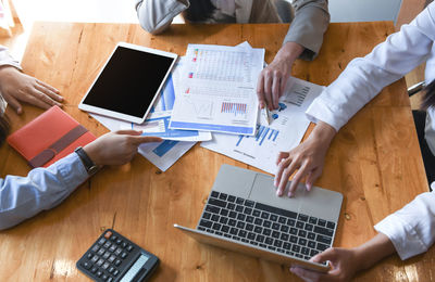 High angle view of people using laptop on table