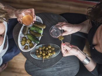 Directly above shot of woman with drinks and pickles