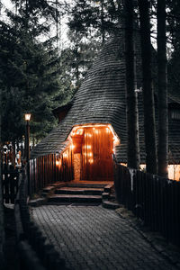 Illuminated footpath by building at night