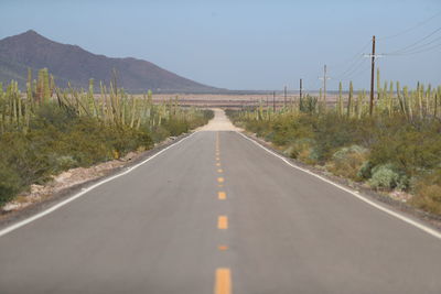 Road leading towards mountain against sky