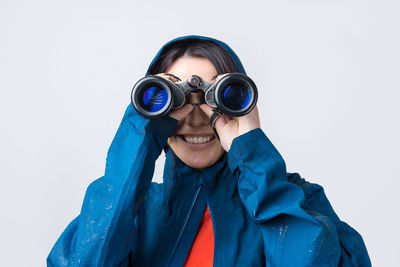 Portrait of woman photographing against clear sky