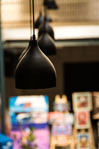 Close-up of illuminated lighting equipment hanging at store