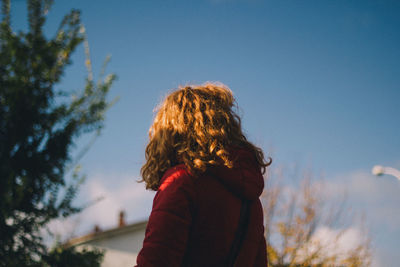 Rear view of woman standing against sky during winter