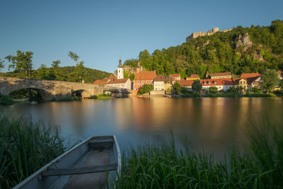 Scenic view of river by buildings against sky