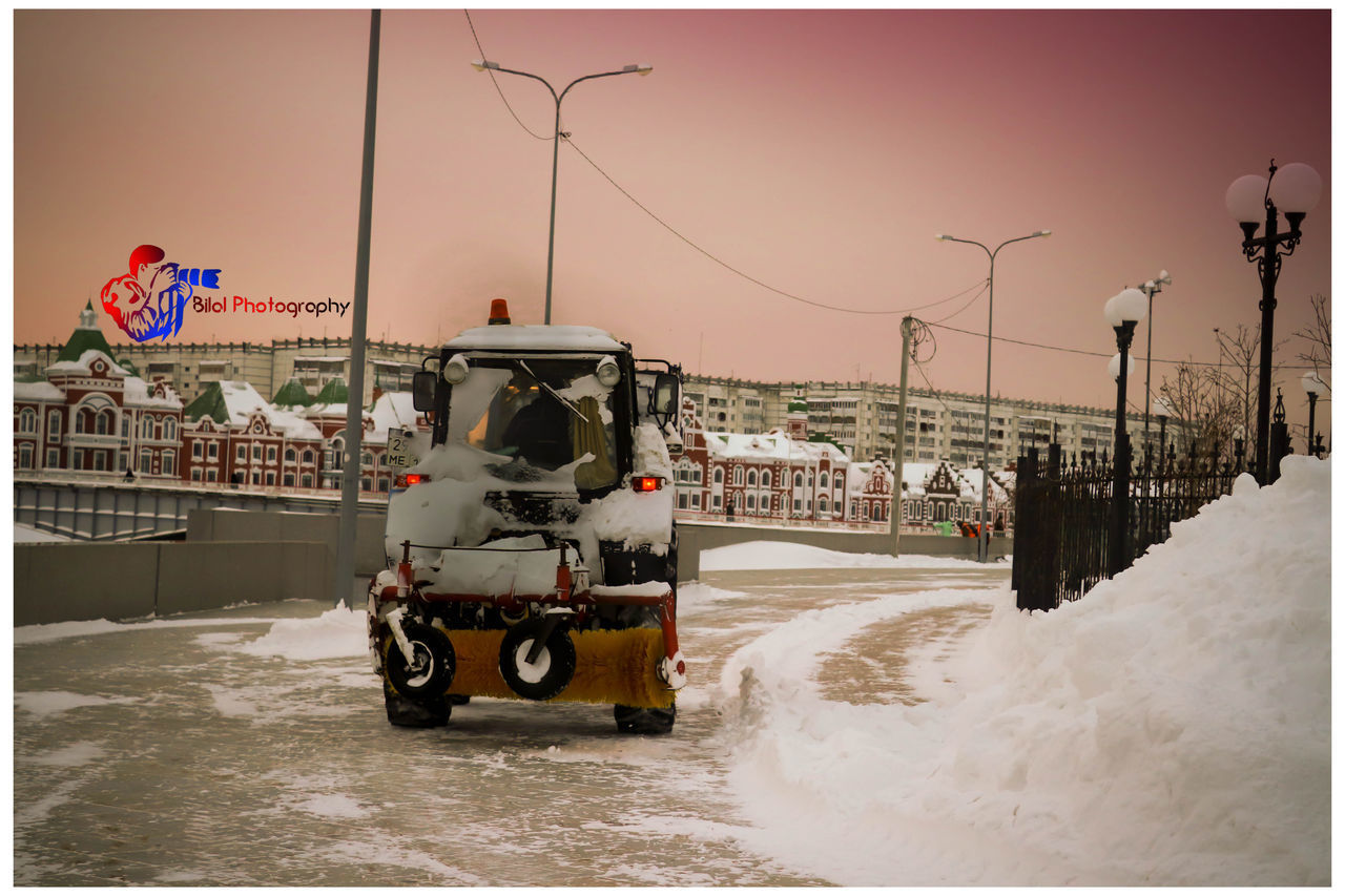 CARS ON ROAD BY SEA AGAINST CLEAR SKY DURING WINTER