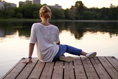 People sitting on pier at lake