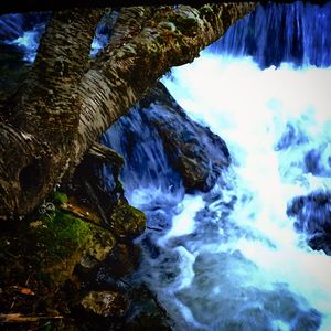 Scenic view of waterfall against sky