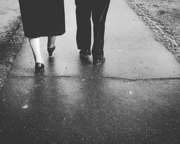 Low section of people standing on wet street